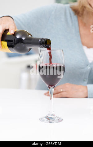 Close up donna versando grande bicchiere di vino rosso Foto Stock