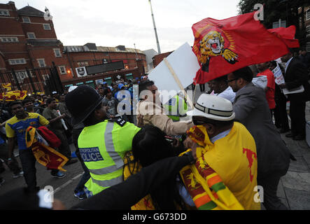 I tifosi di cricket dello Sri Lanka si scontrano con la polizia e i dimostranti dell'espulsa Sri Lanka dal gruppo di protesta del Commonwealth dopo la partita del Trofeo ICC Champions all'Oval di Londra. Foto Stock