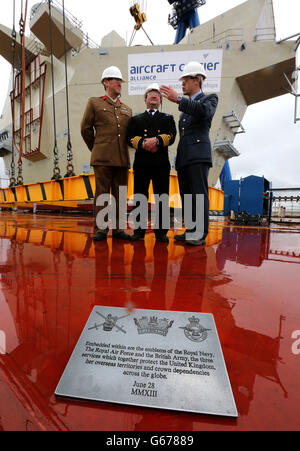 (Da sinistra a destra) Colonnello Stuart Barnard dell'Army Air Corp, CAPT Dickie Payne della Royal Navy e del Capitano del Gruppo David Bradshaw della RAF con una targa con gli emblemi della Royal Navy, la Royal Air Force e l'esercito britannico che saranno incorporati nel tessuto della HMS Queen Elizabeth portaerei dopo che l'ISOLA DI POPPA era Abbassato in posizione al Babcocks Rosyth Dockyard. Foto Stock