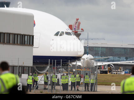 Il personale dell'aeroporto di Heathrow guarda a un British Airways Airbus A380, il più grande aereo passeggeri del mondo, quando arriva all'aeroporto di Heathrow, dato che BA è diventata la prima compagnia aerea britannica a prendere la consegna dell'enorme superjumbo. Foto Stock