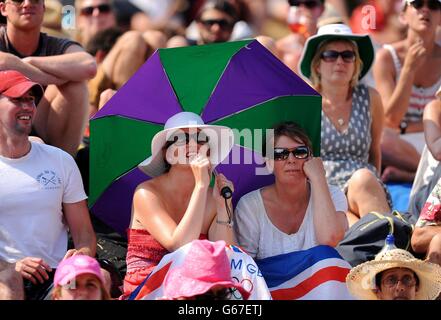 I fan reagiscono su Murray Mount mentre guardano Andy Murray, in Gran Bretagna, che gioca a Novak Djokovic in Serbia nella finale maschile, sul grande schermo durante il tredici° giorno del Wimbledon Championships presso l'All England Lawn Tennis and Croquet Club di Wimbledon. Foto Stock