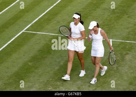 Laura Robson della Gran Bretagna (a sinistra) e Lisa Raymond degli Stati Uniti in conversazione nella loro doppia partita femminile contro Anna-Lena Groenefeld della Germania e Kveta Peschke della Repubblica Ceca durante il sesto giorno del Wimbledon Championships presso l'All England Lawn Tennis and Croquet Club di Wimbledon. Foto Stock