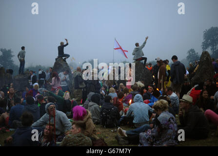 I festeggiatori si riuniscono nel cerchio di pietra all'alba, l'ultimo giorno del Glastonbury Festival of Contemporary Performing Arts del 2013 presso la Pilton Farm, Somerset. Foto Stock