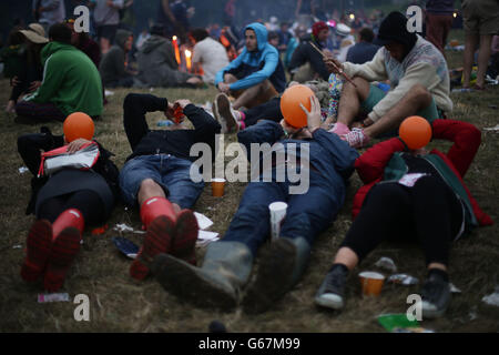 Festival-goers all'alba nel cerchio di pietra, l'ultimo giorno del 2013 Glastonbury Festival of Contemporary Performing Arts at Worthy Farm, Somerset. Foto Stock