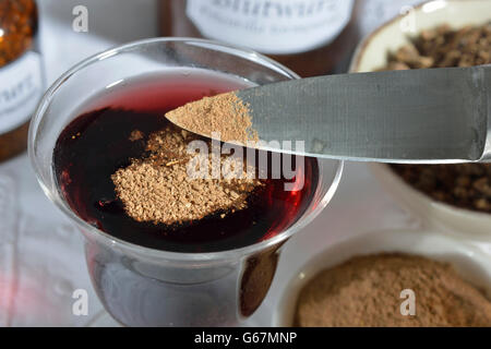 Tormentil radice in polvere nel vino rosso Foto Stock