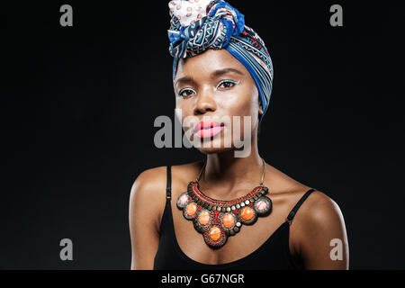 Ritratto di un giovane afro american donna che indossa un velo blu isolato su sfondo nero Foto Stock