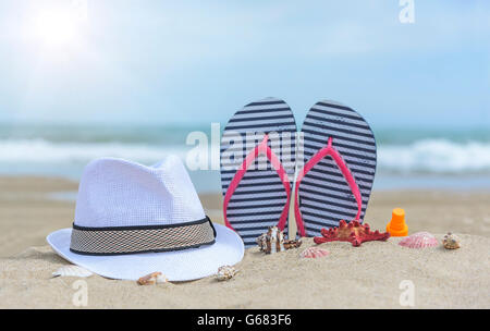 Flip-flop e conchiglie sulla spiaggia. Estate Ancora in vita. Foto Stock