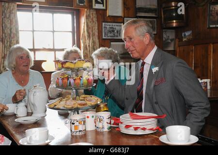 Il Prince of Wales gode di una tazza di tè con i membri del Tuesday Club (da sinistra a destra) Eileen Joseph, Stella Jones e Pauline Staton durante una visita al Prince of Wales Inn, Bridgend. Foto Stock