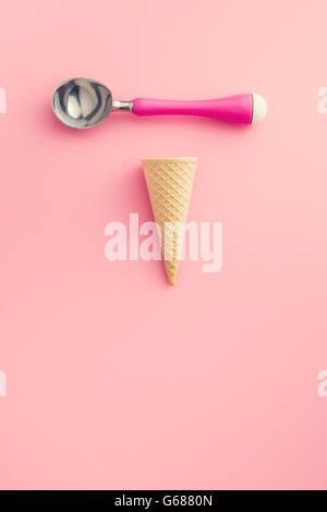 Cono di wafer e gelato scoop su sfondo rosa Foto Stock