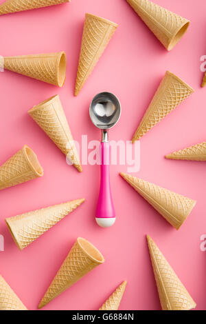 Cono di wafer e gelato scoop su sfondo rosa Foto Stock