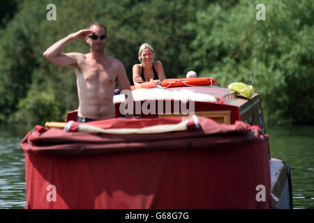 Un uomo e una donna si trovano su una barca stretta sul Tamigi vicino a Penton Hook, Surrey, mentre il caldo continua in tutto il Regno Unito. Foto Stock