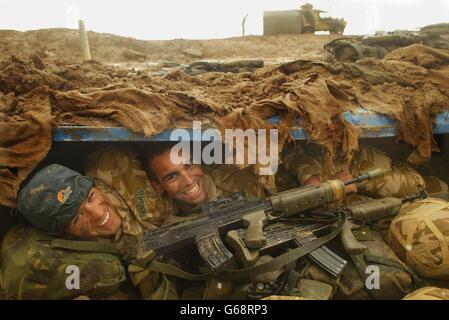 I membri del 40 Commando Royal Marines scavarono a nord della Penisola di al FAW, predicando Basra, dopo forti rainstorms nel deserto, Marine Omar Rawlings, 20, (a sinistra) e Marine Delme King, 24, ripararono nel loro buco della volpe. Foto Stock