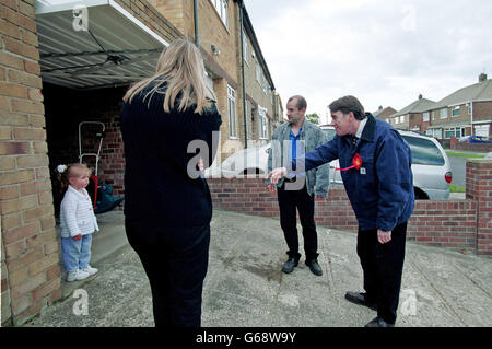 Peter Mandleson MP canvasing destro da porta a porta nella sua circoscrizione di Hartlepool nella Contea di Durham, N e in Inghilterra, per la British 2001 elezione generale. Egli divenne più tardi il commissario europeo per il commercio (2004 e 2008) ed è stata fatta una vita peer. Peter Mandleson tenta di entrare in contatto con un giovane di residente. Foto Stock