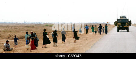 I bambini locali salutano i soldati britannici del 29 Commando Regiment Royal Artillery sulla strada da mentre si spingono verso nord attraverso il sud dell'Iraq. * le forze britanniche hanno infuriato il deserto iracheno per due soldati scomparsi, ma hanno detto che la guerra guidata dagli Stati Uniti potrebbe portare a delle battute d'arresto che hanno colpito sia la campagna aerea che quella terrestre. Foto Stock