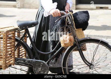 Donna anziana in bicicletta con un cesto pieno di uova fresche Foto Stock