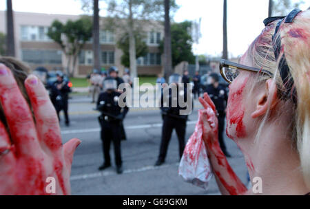 Un attivista della pace coperto di sangue falso davanti alla polizia durante una protesta a Hollywood. La polizia di Los Angeles ha impedito ai dimostranti di guerra contro l'Iraq di raggiungere il Kodak Theatre dove vengono presentati i 75° Academy Awards. Foto Stock