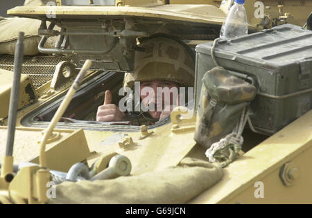 Un membro della settima Brigata corazzata, i ratti del deserto, mentre i residenti fuggono da Basra. La rete si stava chiudendo sui lealisti di Saddam nella città di Basra, sulla scia della più grande offensiva finora in Iraq da parte dei comandos Royal Marine. * per incubo circa 600 Marines reali dal 40 Commando aveva assunto una posizione di consolidamento nel sobborgo meridionale di Abu al Khasib dopo un assalto di 15 ore progettato per incoraggiare gli avversari di Saddam Hussein a Bassora a sollevarsi contro il suo regime. Foto Stock