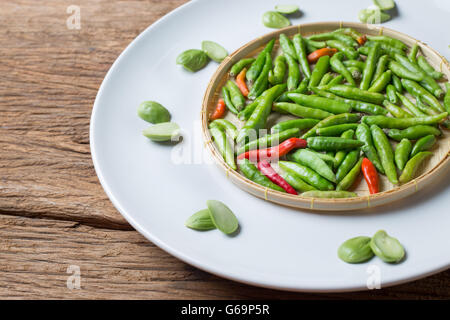 Poco peperoncino tailandese e piccante Parkia speciosa sator bean Basketry sulla piastra bianca ingrediente per il cibo tailandese cucina Foto Stock