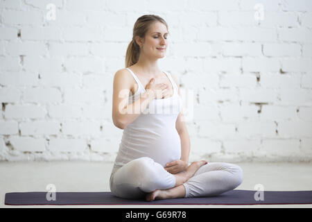 Gravidanza Yoga e fitness concetto. Ritratto di giovane incinta modello yoga che lavora fuori all'interno. Fitness in gravidanza persona sorridente Foto Stock