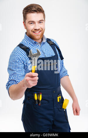 Sorridente builder maschio tenendo la chiave isolato su uno sfondo bianco Foto Stock