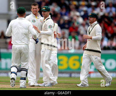 Peter Siddle (al centro a sinistra) festeggia con il capitano Michael Clarke dopo aver preso il cricket di Graeme Swann in Inghilterra durante il quarto giorno della terza prova di Investec Ashes all'Old Trafford Cricket Ground di Manchester. Foto Stock