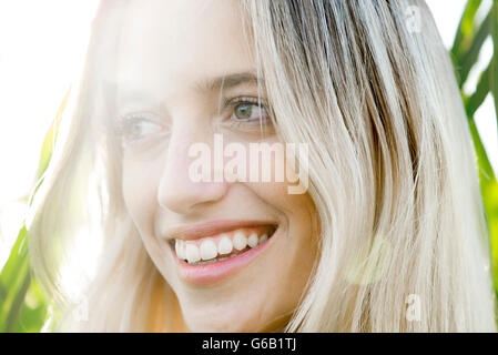 Giovane donna sorridente nel pensiero all'aperto Foto Stock