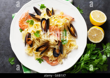 Pasta con frutti di mare sul tavolo di pietra. Cozze e gamberi. Vista superiore Foto Stock