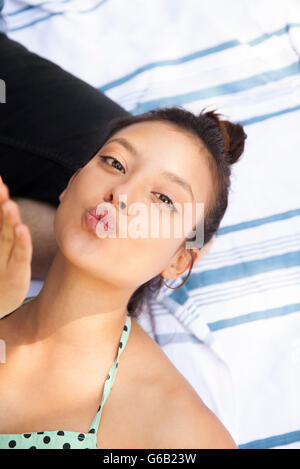 Giovane donna bacio di soffiatura Foto Stock