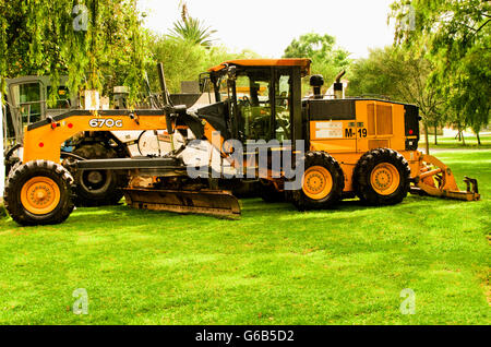 Grande giallo motolivellatrice parcheggiato su erba verde, molto bello constrasts colore Foto Stock