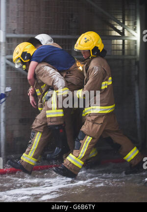 (160624) -- HONG KONG, Jun. 24, 2016 (Xinhua) -- Vigili del Fuoco effettuare un ferito fellow presso un ardente a più piani edificio industriale in Kowloon East area di Hong Kong, Cina del Sud, 23 giugno 2016. Un secondo vigile del fuoco è morto la sera di giovedì dopo aver combattuto a quattro-allarme incendio che infuria per più di due giorni in un edificio industriale di Kowloon Bay. (Xinhua/Ng Wing Kin) (Cxy) Foto Stock