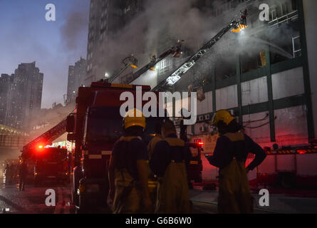 (160624) -- HONG KONG, Jun. 24, 2016 (Xinhua) -- i vigili del fuoco lavorare per mettere fuori fuoco a un multipiano di edificio industriale in Kowloon East area di Hong Kong, Cina del Sud, 23 giugno 2016. Un secondo vigile del fuoco è morto la sera di giovedì dopo aver combattuto a quattro-allarme incendio che infuria per più di due giorni in un edificio industriale di Kowloon Bay. (Xinhua/Ng Wing Kin) (Cxy) Foto Stock