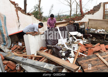 (160624) -- YANCHENG, Giugno 24, 2016 (Xinhua) -- abitante Qinian Wang e sua moglie sono visibili nella loro casa collassato in Danping villaggio di Chenliang township di Funing, Yancheng oriente cinese della provincia di Jiangsu, Giugno 24, 2016. Un totale di 98 persone sono state uccise dopo forti tempeste in diverse città dello Jiangsu giovedì, salvataggio locale sede detto venerdì. Circa 846 persone subito lesioni, 200 dei quali sono stati gravemente feriti, ha detto. Più di 8.600 case, due scuole elementari e la fabbrica di otto edifici furono danneggiati nelle contee di Funing e Sheyang, e parti di Yancheng città alon Foto Stock