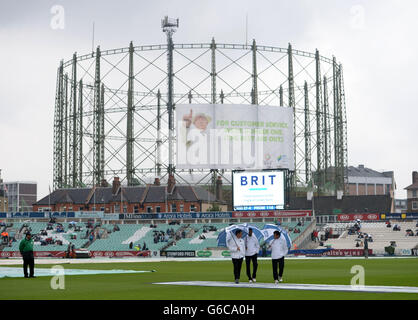 Gli umpires Richard Kettleborough, (a sinistra) Aleem Dar (a destra) e Kumar Dharmasena (al centro) camminano intorno al campo mentre più pioggia cade il giorno quattro della partita di prova di Fifth Investec Ashes al Kia Oval, Londra. Foto Stock