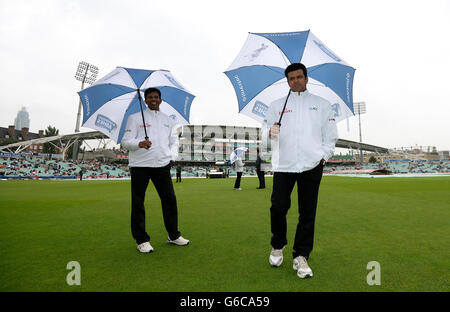 Gli imperi Aleem Dar (a destra) e Kumar Dharmasena ispezionano il tempo del quarto giorno del quinto test Ashes al Kia Oval mentre la pioggia ritarda l'inizio del gioco Foto Stock