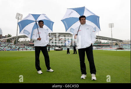 Gli imperi Aleem Dar (a destra) e Kumar Dharmasena ispezionano il tempo del quarto giorno del quinto test Ashes al Kia Oval mentre la pioggia ritarda l'inizio del gioco Foto Stock