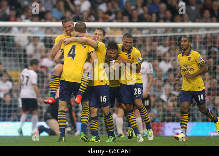 Lukas Podolski di Arsenal celebra il suo primo gol durante la partita Barclays Premier League a Craven Cottage, Londra. Foto Stock