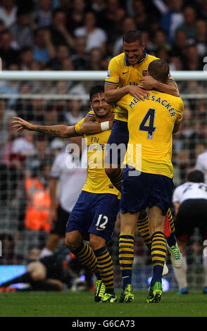 Lukas Podolski di Arsenal celebra il suo primo gol durante la partita Barclays Premier League a Craven Cottage, Londra. Foto Stock