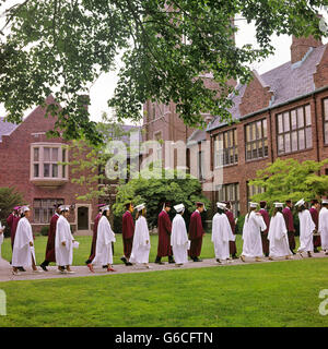 Anni Settanta un gruppo di studenti che indossano cappucci E ABITI A PIEDI IN PROCESSIONE DI GRADUAZIONE Foto Stock