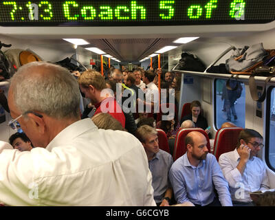 Le persone a bordo di un affollato treno South West in direzione di Portsmouth, come pendolari nel sud-est dell'Inghilterra sono stati esortati a considerare di lasciare lavorare presto come interruzioni alla rete ferroviaria continua a seguito piogge torrenziali e temporali. Foto Stock