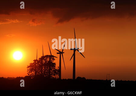 Il sole tramonta sulle turbine eoliche vicino a Faringdon, Oxfordshire. Foto Stock