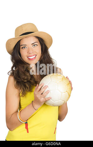 Ispanico brunette indossando giallo football shirt e hat, posa per telecamera tenendo palla, bianco di sfondo per studio Foto Stock