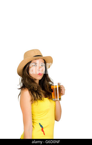 Ispanico brunette indossando giallo football shirt e hat, posa per fotocamera mentre bere dal bicchiere da birra, bianco di sfondo per studio Foto Stock