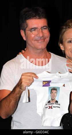 Simon Cowell tiene un babygrow in una foto-call al RADA di Londra per lanciare l'X Factor Musical 'i Cant sing'. Foto Stock