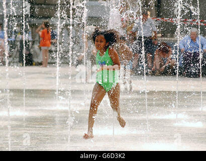 Una giovane ragazza si tuffa in una fontana a Somerset House, Londra, mentre la Gran Bretagna continua a godersi l'incantesimo soleggiato. PA Foto: Lindsey Parnaby. Foto Stock