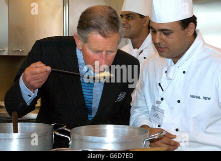 Il Principe di Galles durante la sua visita a Noon Products a Southall. Vestito con un abito a righe con una camicia a righe e cravatta blu pallido, il principe rise e scherzò con gli chef nella cucina all'avanguardia. * il principe ha assaporato l'aroma di un'iva di cottura di pollo di Achari, un curry caldo sottaceto. Foto Stock