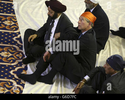 Il Principe del Galles, indossando una sciarpa Ramal arancione brillante al tempio Sikh di Sri Guru Singh Sabha Gurdwara, a Southall. * il principe tolse anche le sue scarpe nel rispetto della religione Sikh prima di essere portato al servizio dove si sedette a gambe incrociate su un cuscino. Un inno di benvenuto è stato letto per il Principe nella sala di preghiera. Gli fu poi presentata una Siropa all'altare: Una spada cerimoniale, una stalla d'onore, uno scialle per la Regina e un libro commemorativo. Foto Stock