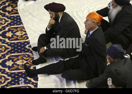 Il Principe del Galles, indossando una sciarpa Ramal arancione brillante al tempio Sikh di Sri Guru Singh Sabha Gurdwara, a Southall. * il principe tolse anche le sue scarpe nel rispetto della religione Sikh prima di essere portato al servizio dove si sedette a gambe incrociate su un cuscino. Un inno di benvenuto è stato letto per il Principe nella sala di preghiera. Gli fu poi presentata una Siropa all'altare: Una spada cerimoniale, una stalla d'onore, uno scialle per la Regina e un libro commemorativo. Foto Stock