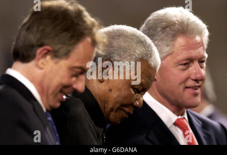 L'ex presidente sudafricano Nelson Mandela (al centro) è aiutato dal podio dal primo ministro britannico Tony Blair (a sinistra) e dall'ex presidente americano Bill Clinton, durante una serata di gala in occasione del centenario del Rhodes Trust, e dalla creazione della Mandela Rhodes Foundation, a Westminster. Foto Stock