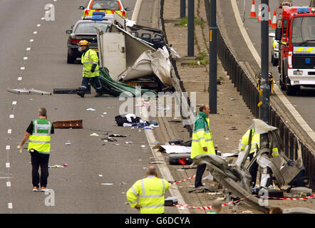 Personale di servizio di emergenza sulla scena sulla M56 a sud di Manchester, dove un cumulo di quattro veicoli ha lasciato sette persone morte e altri due combattimenti per la loro vita. * l'incidente, che ha coinvolto un minibus (in alto al centro della foto) e altri tre veicoli, è accaduto vicino al bivio 4 vicino a Wythenshawe. Si ritiene che tutte le persone uccise e ferite gravi abbiano viaggiato in minibus. Foto Stock