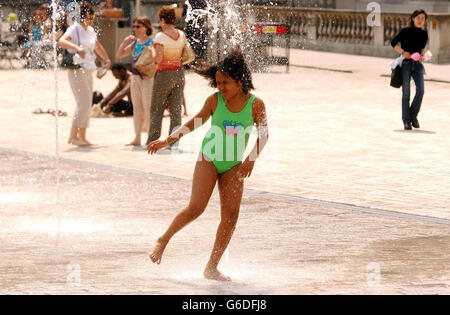 Una giovane ragazza fa un tuffo in una fontana a Somerset House, Londra, mentre la Gran Bretagna continua a godere dell'incantesimo soleggiato. Foto Stock